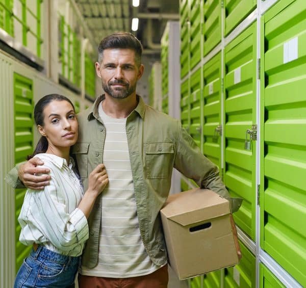 Jeune couple posant devant des casiers de rangement verts.