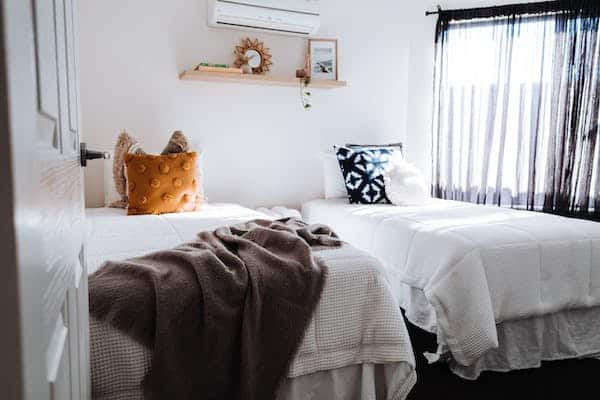 Deux lits dans une chambre avec fenêtre.