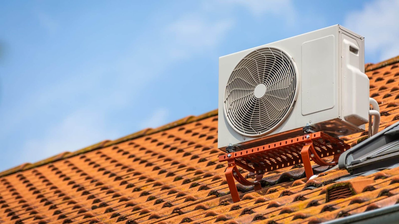 Un climatiseur est installé au sommet d’un toit.