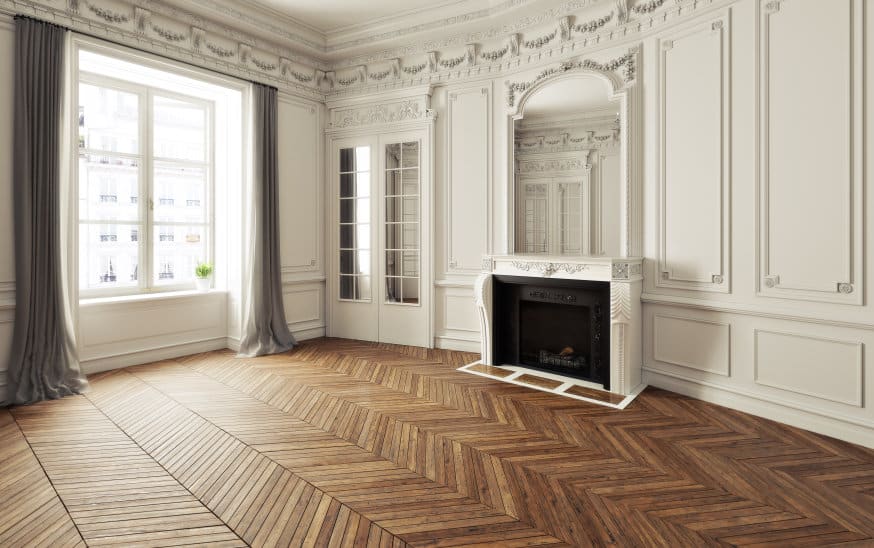 Une pièce vide avec des murs blancs et du parquet.