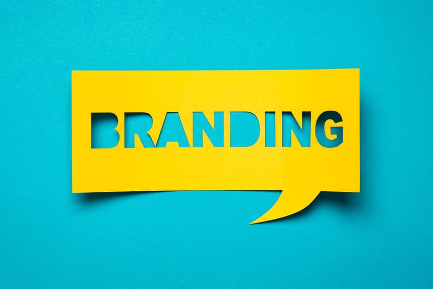 Une bulle de dialogue jaune avec le mot « BRANDING » découpé, sur fond bleu sarcelle.
