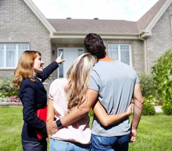 Trois personnes devant une nouvelle maison.