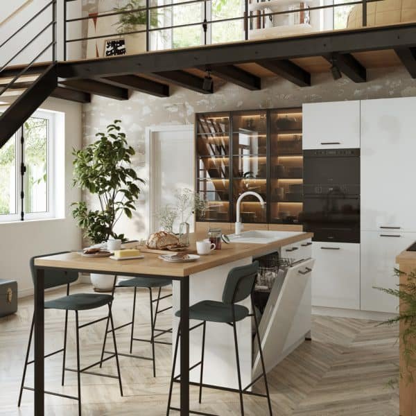 Cuisine moderne avec armoires blanches, îlot avec comptoir en bois, tabourets de bar, appareils encastrés, plantes et étagères ouvertes sous un escalier dans un espace de style loft.