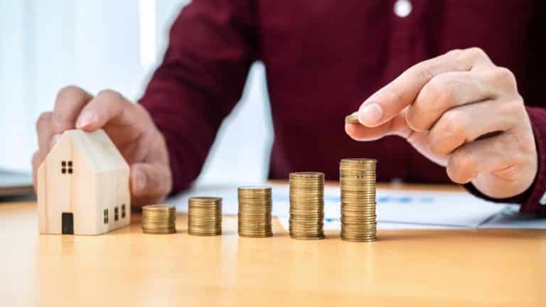 74233 437 asian business man holding coin to putting on coins stack to touching house model and checking chart t20 YN3g3W