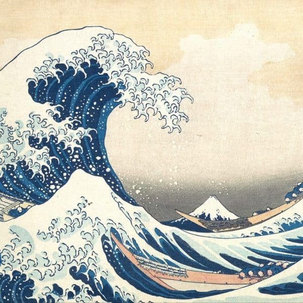 Une estampe japonaise traditionnelle représentant de grandes vagues océaniques et une vue lointaine du mont Fuji, avec des bateaux luttant contre l'eau.