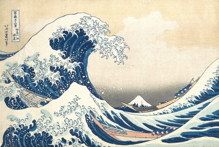 Une estampe japonaise traditionnelle représentant de grandes vagues océaniques et une vue lointaine du mont Fuji, avec des bateaux luttant contre l'eau.