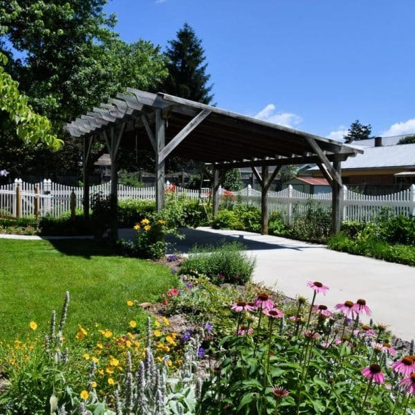 Un jardin fleuri et un abri pour voitures