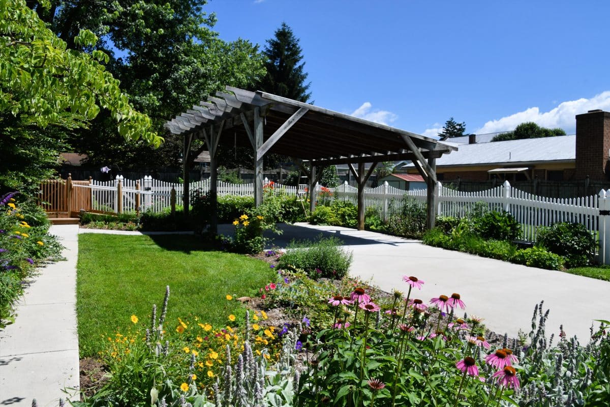 Un jardin fleuri et un abri pour voitures