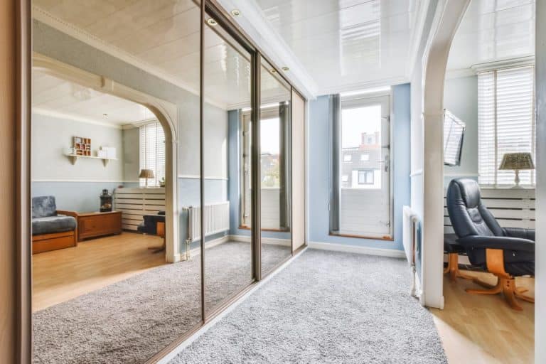 A narrow room with a mirrored wardrobe