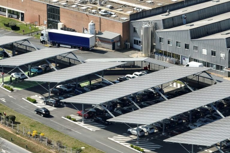 Vue aérienne de panneaux solaires installés au-dessus d'un parking avec des voitures garées