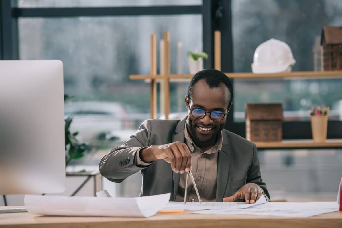 Un homme architecte à lunettes travaille sur un projet dans son bureau.