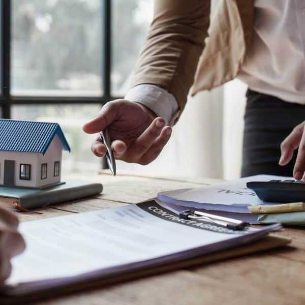 Gros plan Des hommes d'affaires ou un agent immobilier expliquent au client la signature d'un contrat de vente de maison.