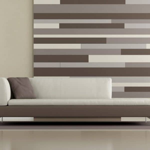 Salon moderne avec un canapé blanc, un lampadaire et une plante en pot contre un mur avec des panneaux à rayures horizontales dans des tons neutres.