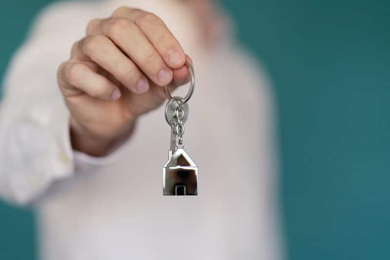 Un homme tenant une clé avec une maison dessus.