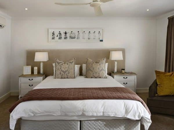 Une chambre avec un lit et un ventilateur de plafond.