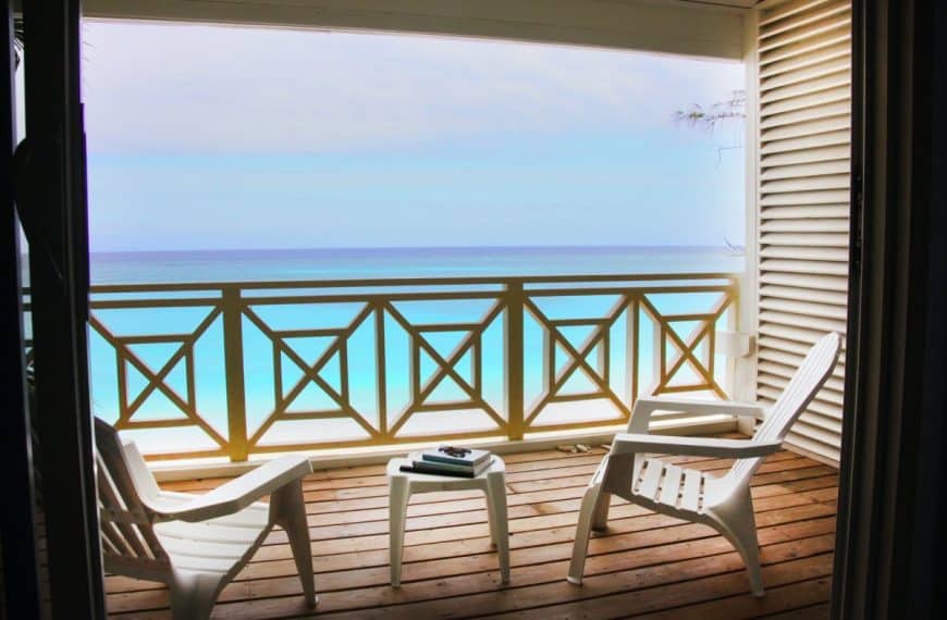 Une terrasse en bois avec des chaises et une table dessus.