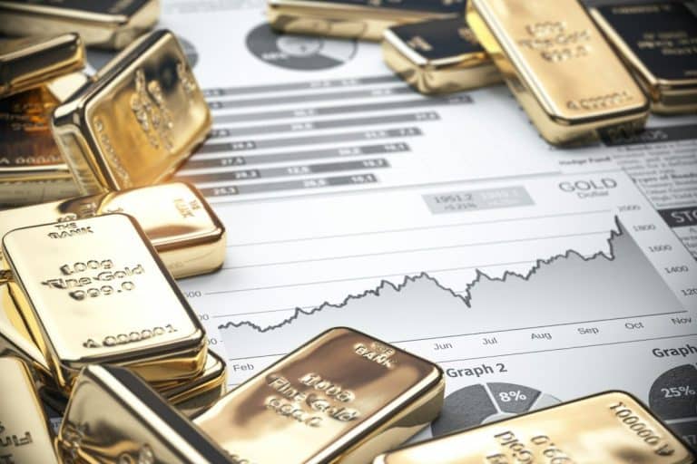 Lingots d'or dispersés sur un graphique financier, montrant les tendances du marché et les graphiques de données en arrière-plan.