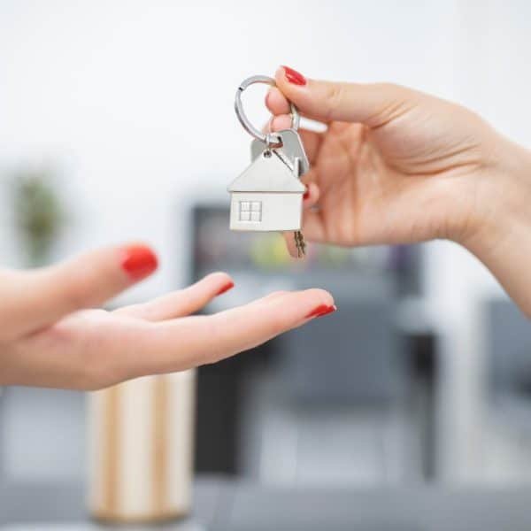 hands handing over keys for property purchase