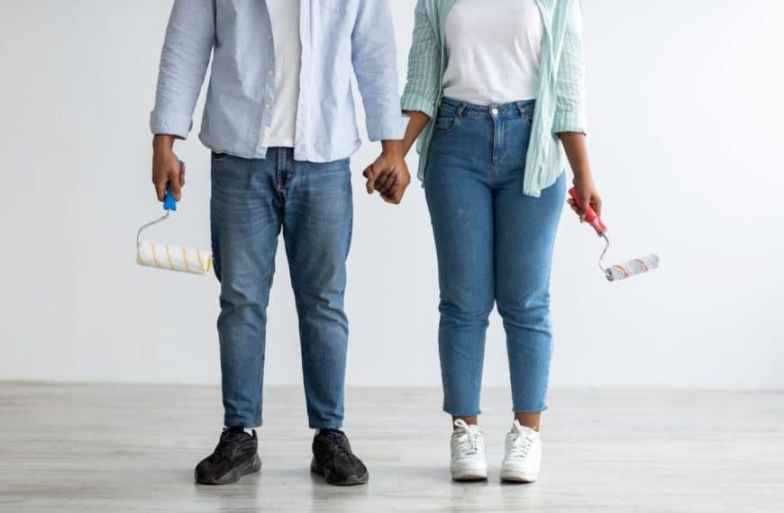 Home renovation, decoration and painting. African american couple with paint rollers posing in their