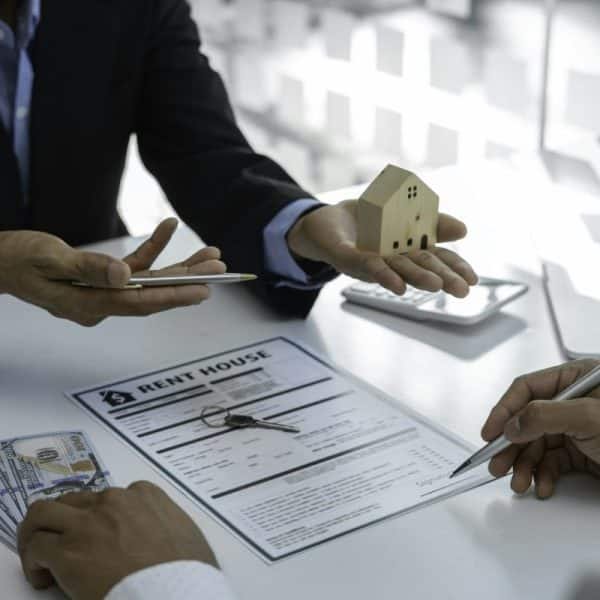 Plans de maisons avec des agents immobiliers et des clients discutant de contrats d'achat de maisons, de prêts immobiliers, etc.