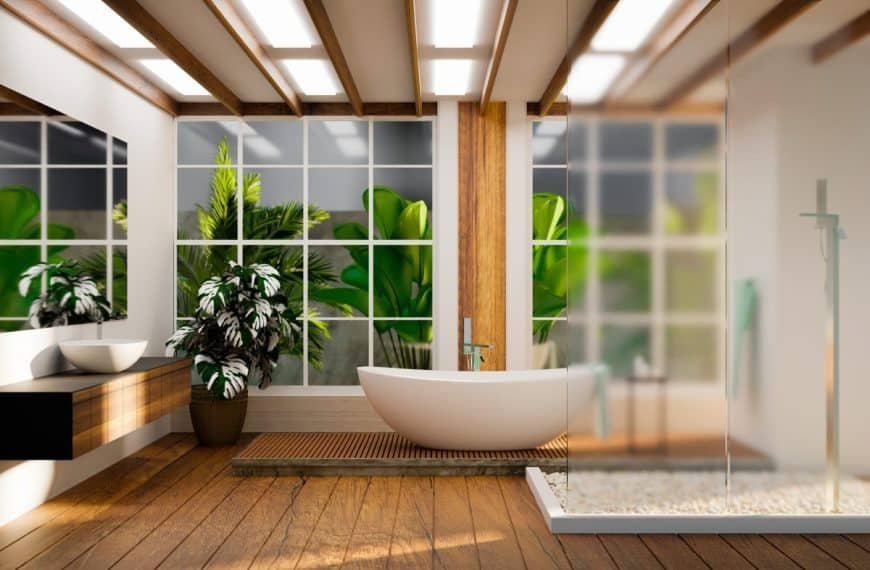 Salle de bain moderne avec baignoire autoportante, plancher en bois, grande fenêtre et plantes d'intérieur.