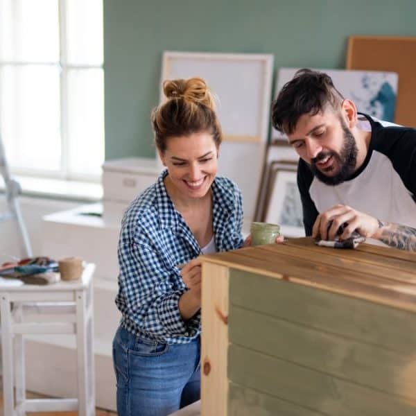 Mid adults couple painting furniture indoors at home, relocation and diy concept