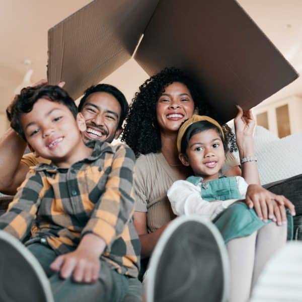 New home, family and portrait with cardboard box for moving, mortgage and property purchase. Living
