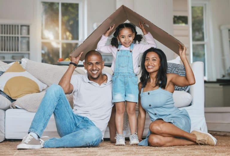 Portrait, toit en carton et famille dans le salon, assurance habitation et soins avec protection, sourire a