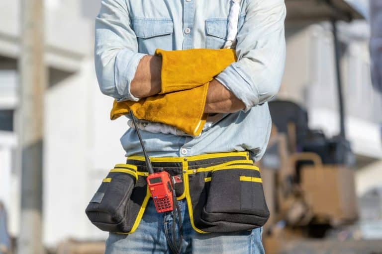 Portrait d'un électricien portant un harnais de sécurité sur un chantier de construction.