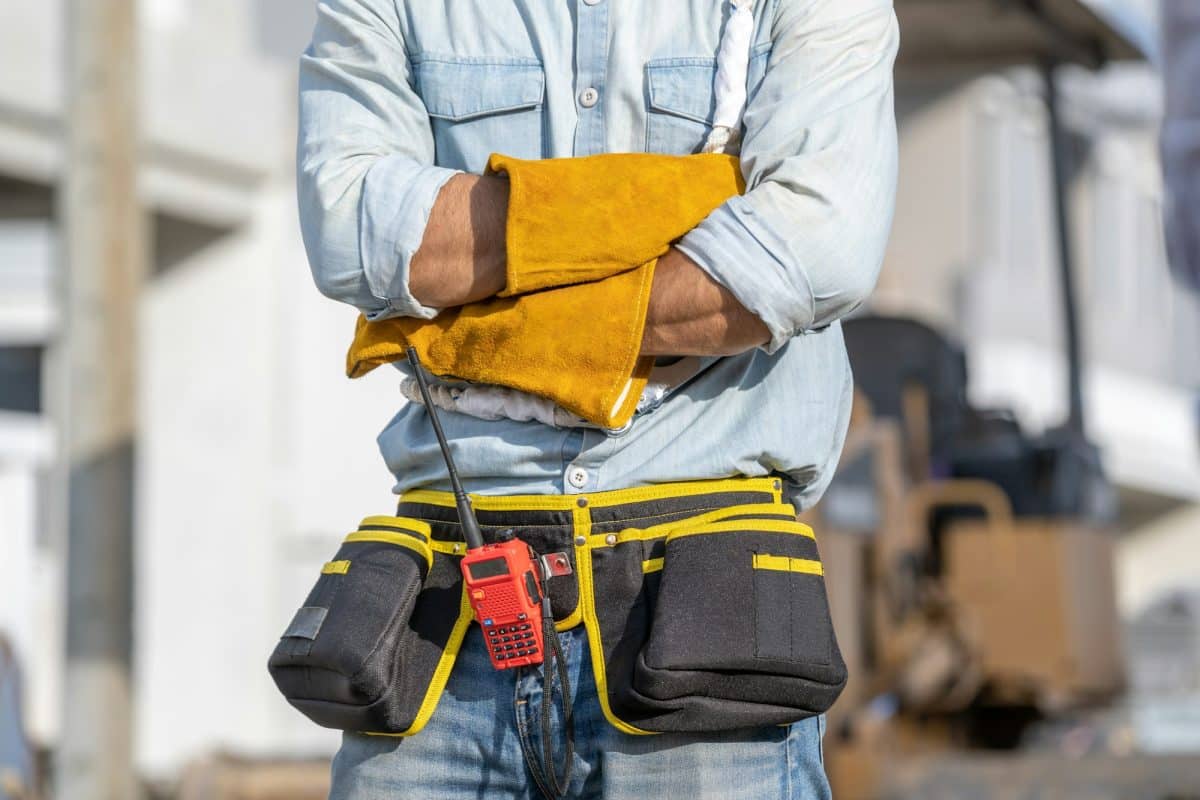 Portrait d'un électricien portant un harnais de sécurité sur un chantier de construction.