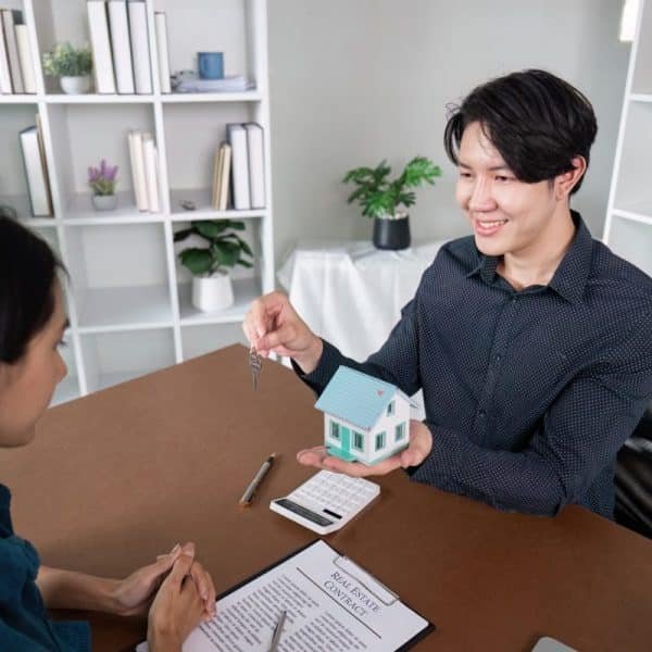 Real Estate Agent Finalizing Deal with Key Handover to Client