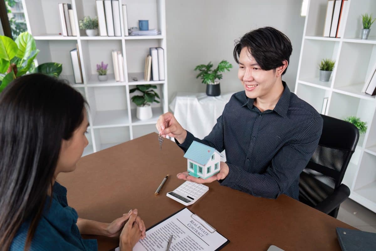Real Estate Agent Finalizing Deal with Key Handover to Client