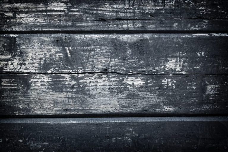 Planches de bois patinées avec peinture écaillée et texture de grain visible, alignées horizontalement.