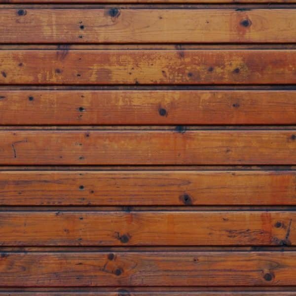 Un gros plan d'un mur en bois composé de planches horizontales. Le bois est teinté d’une couleur brun chaud, présentant divers nœuds et motifs de grain.