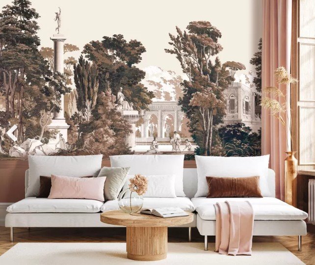 Un salon avec un canapé modulable blanc, des coussins roses et marron, une table basse ronde en bois et une fresque murale représentant une scène de jardin classique avec des arbres, des statues et des arcades.