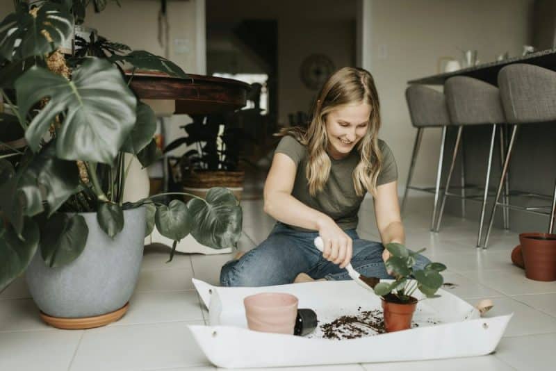 Smiling girl enjoying gardening indoors