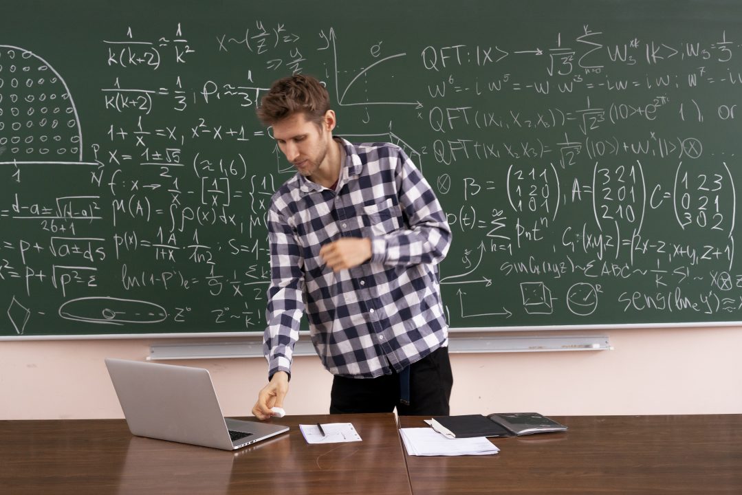the adult student sitting at the table and working laptop, doing homework research