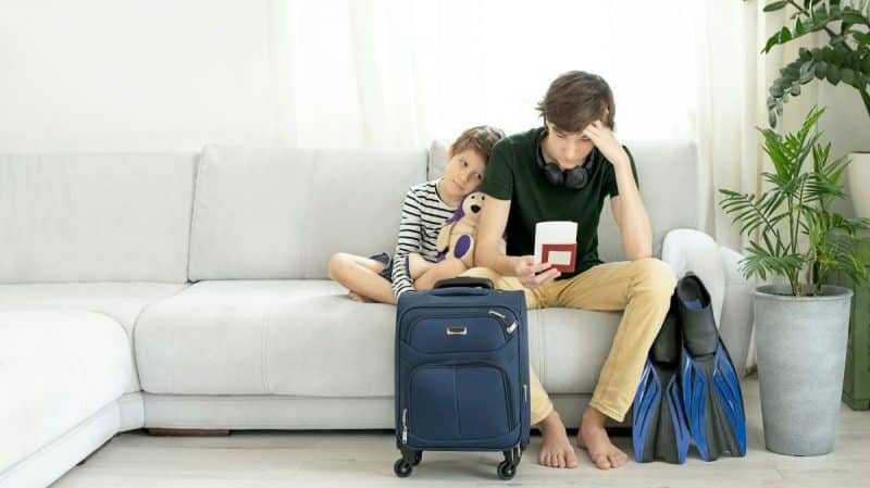 Two sad tourists with a passport and tickets in hands. Closed borders, cancellation of departure
