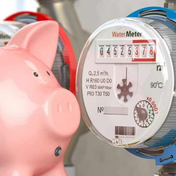 Une tirelire rose est placée à côté d'un compteur d'eau affichant "4525378". Le compteur est accompagné de diverses spécifications techniques.