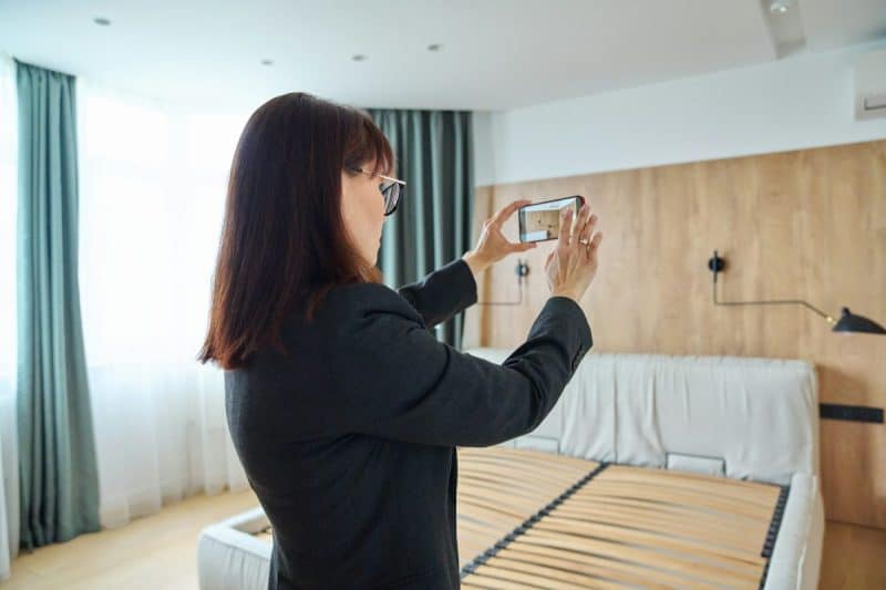 Woman real estate agent photographing furnished apartment