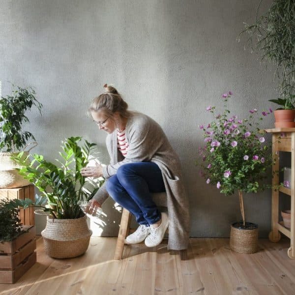 Woman tending to potted plants in indoor garden