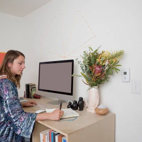 Woman working at a home office desk with stylish decor
