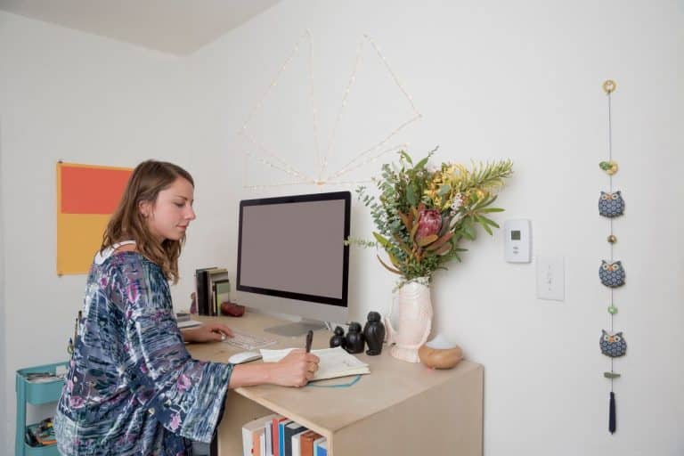 Woman working at a home office desk with stylish decor