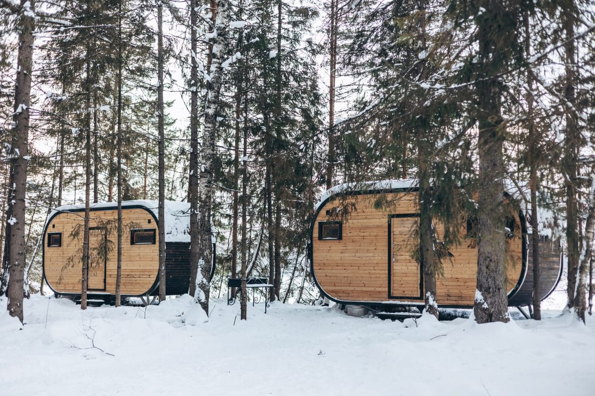 Deux cabanes en bois dans la neige dans les bois.