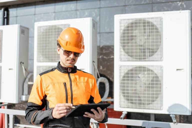 Un homme portant un casque de sécurité et tenant une tablette.