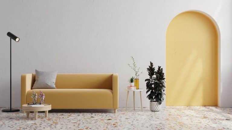 Yellow sofa with plant on white wall and Terrazzo flooring.