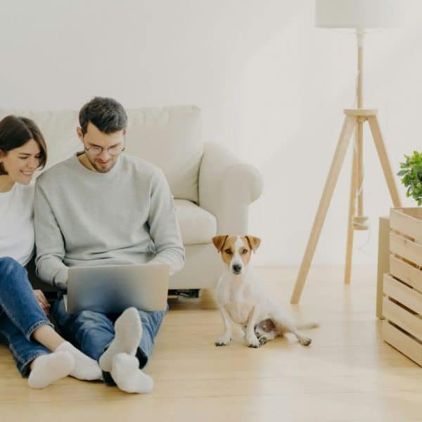 Jeune couple européen rénovant sa maison, concentré sur son ordinateur portable.