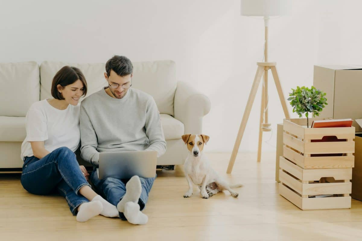 Jeune couple européen rénovant sa maison, concentré sur son ordinateur portable.